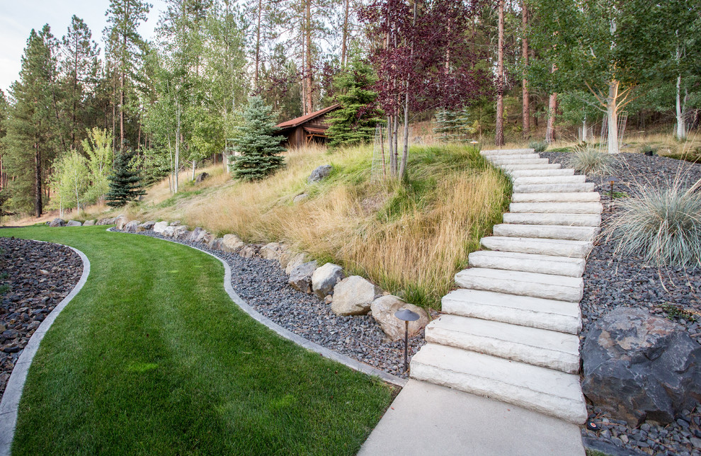 Photo of a large rustic concrete curved landscaping with concrete risers.