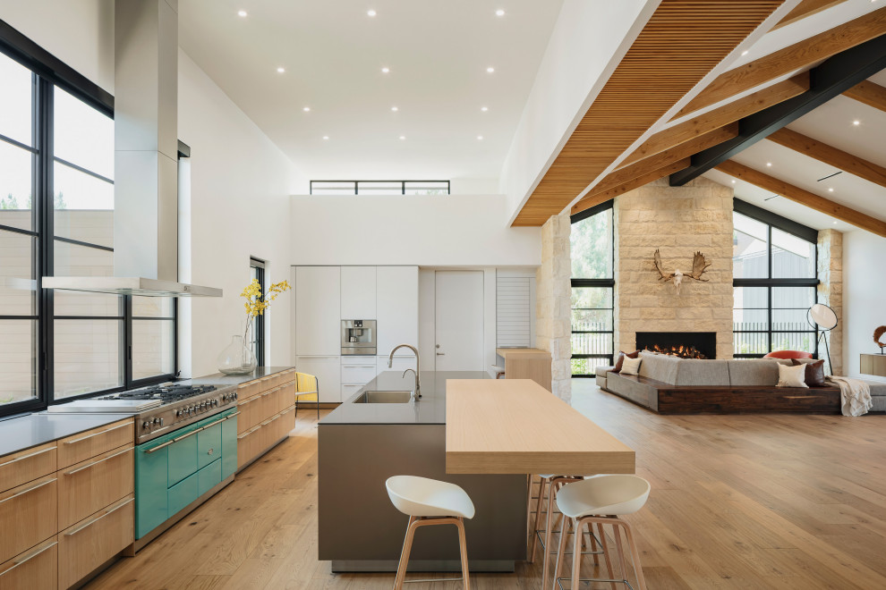 Inspiration for a large contemporary open plan kitchen in Phoenix with a submerged sink, flat-panel cabinets, engineered stone countertops, white splashback, glass sheet splashback, coloured appliances, medium hardwood flooring, an island, grey worktops and a wood ceiling.