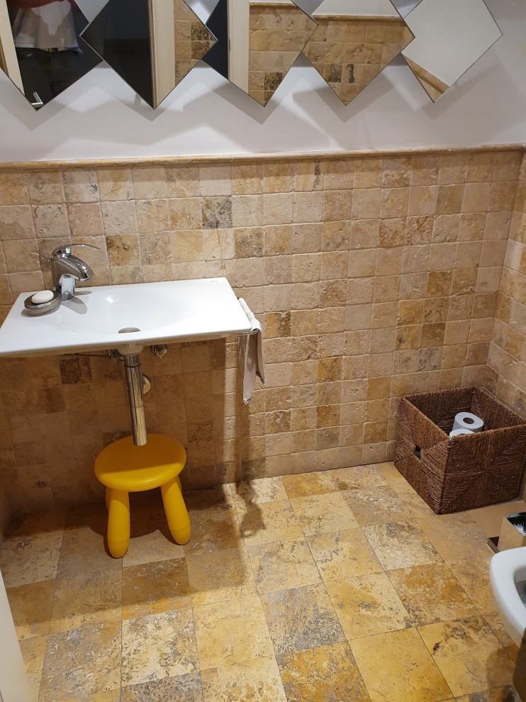 Inredning av ett modernt mellanstort vit vitt badrum för barn, med en toalettstol med hel cisternkåpa, beige kakel, travertinkakel, beige väggar, kalkstensgolv, ett undermonterad handfat och beiget golv