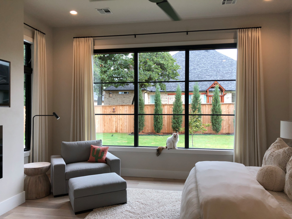 Photo of a modern master bedroom in Oklahoma City with vinyl flooring, a standard fireplace and a plastered fireplace surround.