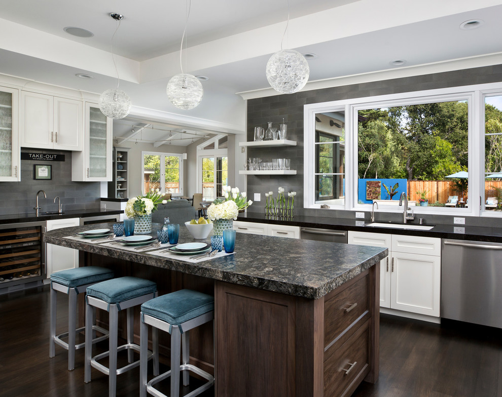 Photo of a mid-sized transitional l-shaped kitchen in San Francisco with recessed-panel cabinets, white cabinets, granite benchtops, grey splashback, metal splashback, stainless steel appliances, dark hardwood floors and with island.