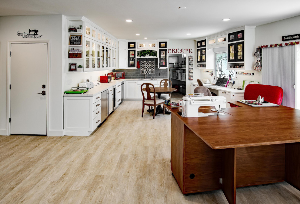 Exemple d'un grand bureau atelier chic avec un mur blanc, un sol en vinyl, un bureau intégré et un sol marron.
