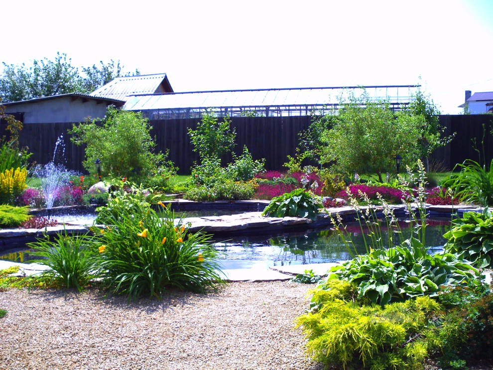 Современный сад с большим прудом.