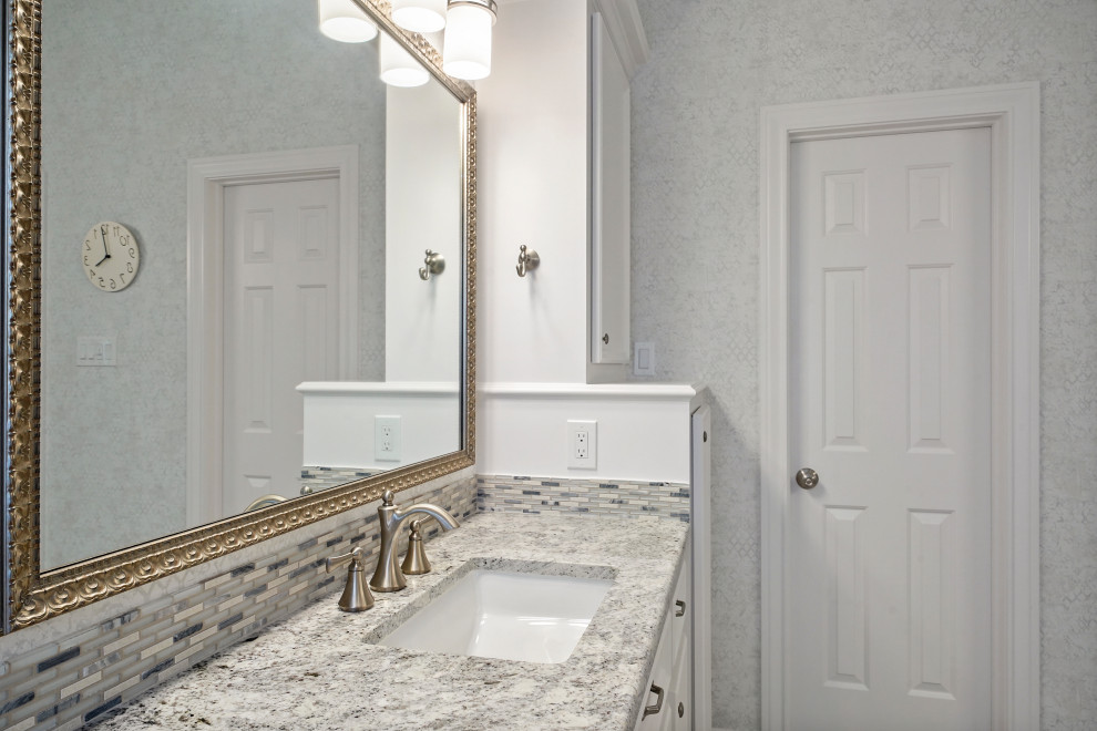 Cette image montre une salle de bain principale design de taille moyenne avec un placard avec porte à panneau surélevé, des portes de placard blanches, une baignoire indépendante, une douche d'angle, WC séparés, un carrelage blanc, des carreaux de céramique, un mur blanc, un sol en carrelage de céramique, un lavabo encastré, un plan de toilette en granite, un sol blanc, une cabine de douche à porte battante, un plan de toilette gris, un banc de douche, meuble double vasque, meuble-lavabo encastré, un plafond à caissons et du papier peint.