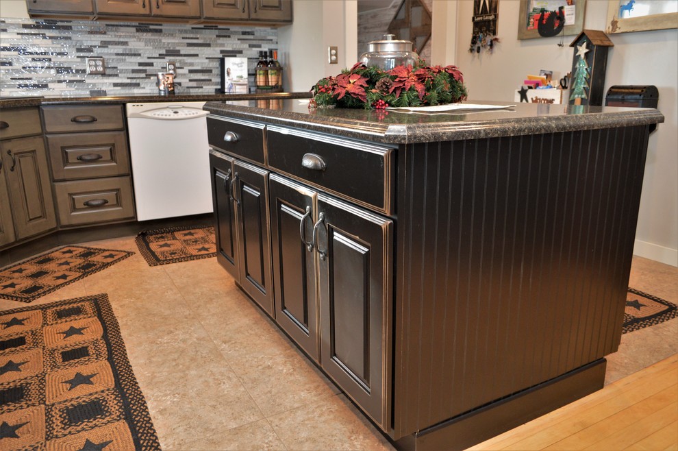 This is an example of a mid-sized country l-shaped eat-in kitchen in Chicago with a drop-in sink, raised-panel cabinets, black cabinets, laminate benchtops, multi-coloured splashback, matchstick tile splashback, multiple islands and brown benchtop.