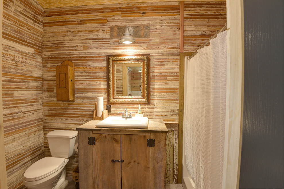 Photo of a country bathroom in Other with shaker cabinets, light wood cabinets, an open shower, wood benchtops, a shower curtain, a single vanity, a freestanding vanity and wood walls.