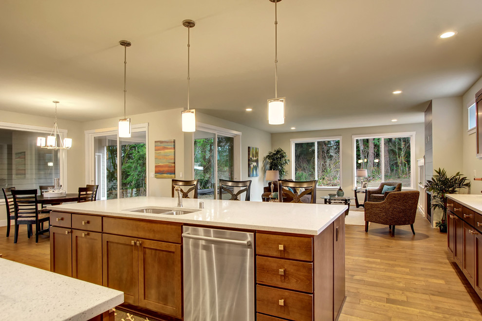 Expansive transitional l-shaped eat-in kitchen in Seattle with an undermount sink, shaker cabinets, dark wood cabinets, quartz benchtops, grey splashback, ceramic splashback, stainless steel appliances, medium hardwood floors and with island.