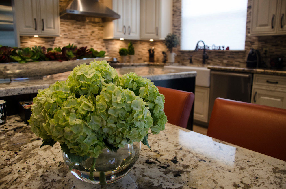 Inspiration for a large transitional l-shaped porcelain tile open concept kitchen remodel in Miami with a farmhouse sink, raised-panel cabinets, white cabinets, granite countertops, multicolored backsplash, mosaic tile backsplash, stainless steel appliances and an island