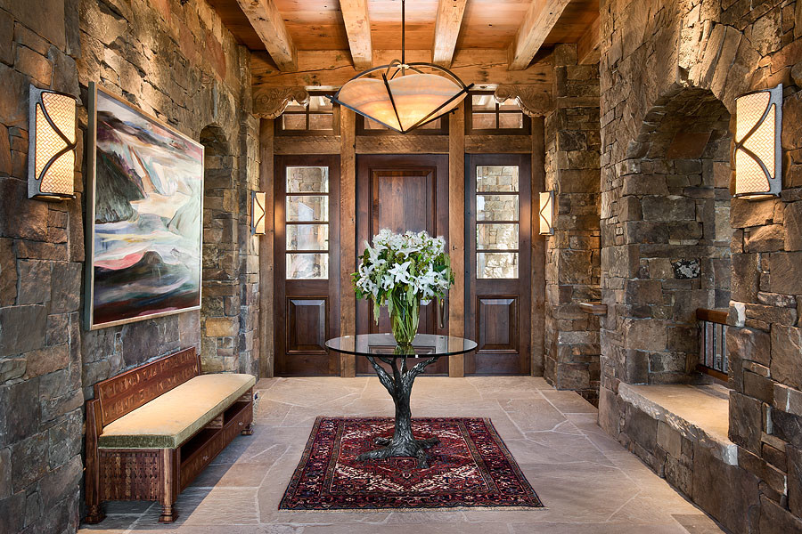 Example of a mountain style slate floor foyer design with a dark wood front door