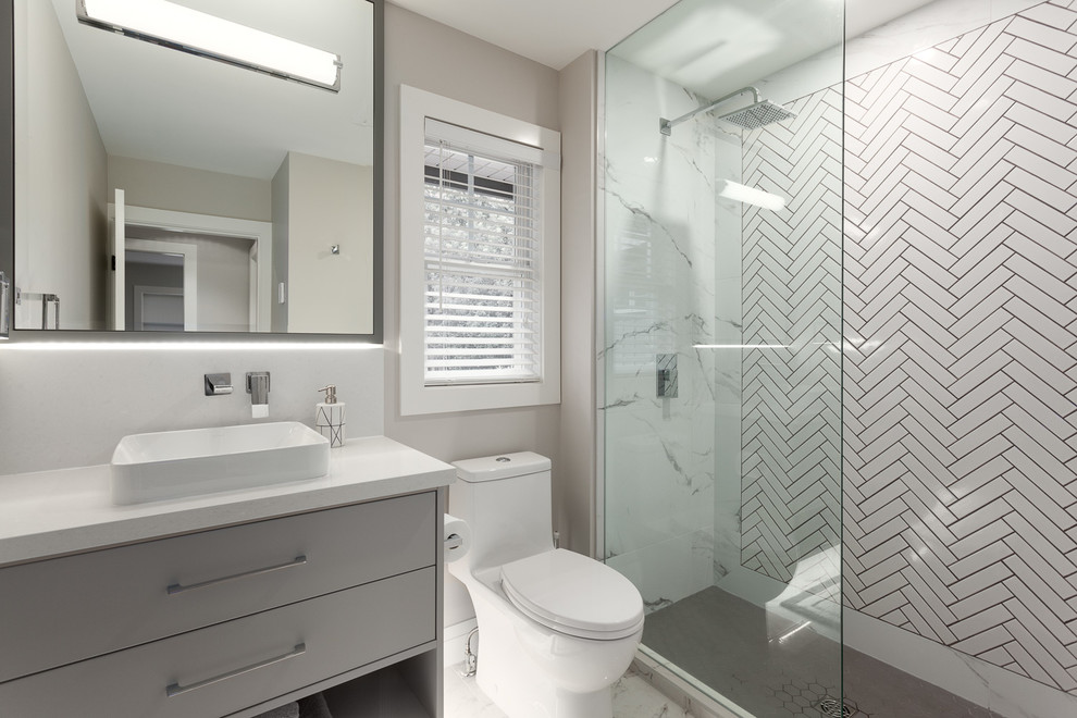 Mid-sized modern 3/4 bathroom in Vancouver with flat-panel cabinets, an alcove shower, a one-piece toilet, white tile, ceramic tile, grey walls, engineered quartz benchtops, white floor, an open shower, grey cabinets, marble floors and a vessel sink.