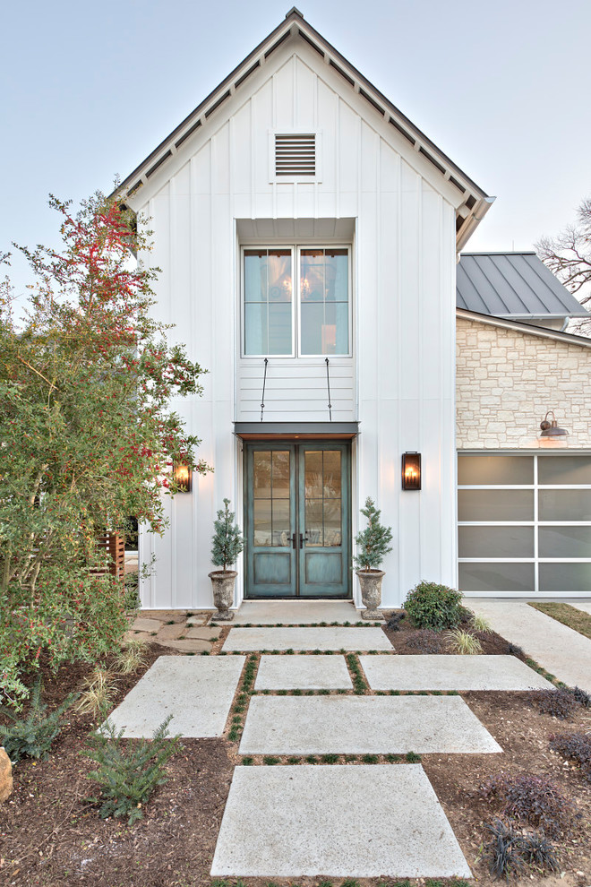 Photo of a large transitional two-storey white house exterior in Austin with mixed siding, a gable roof and a metal roof.