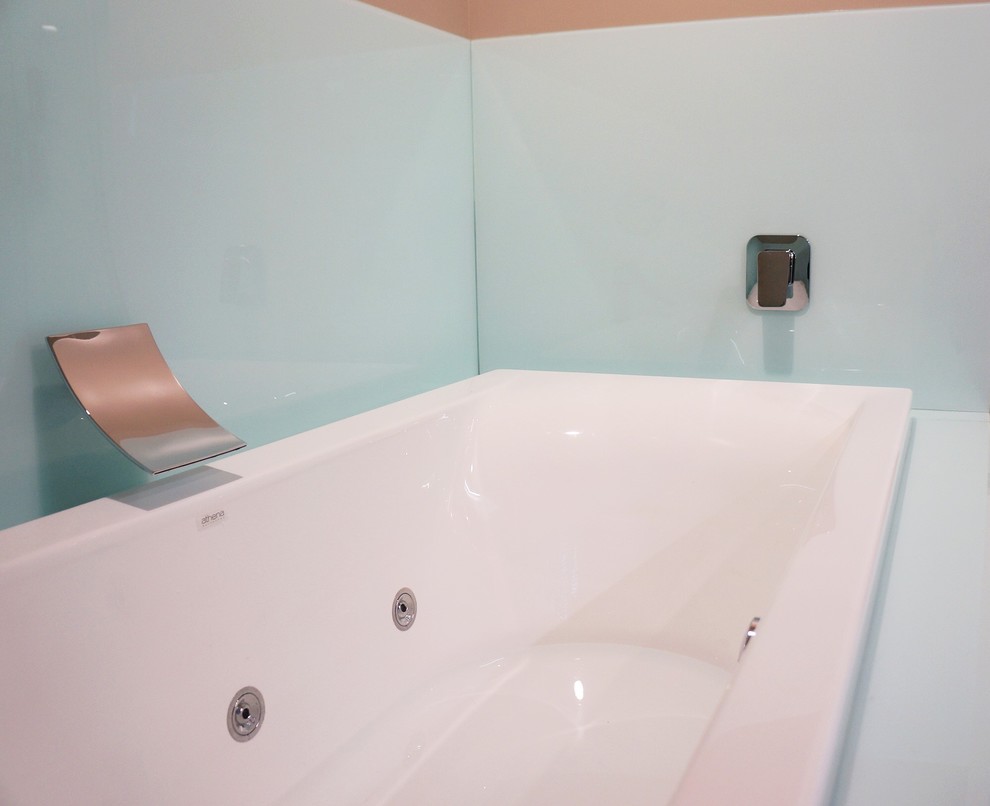 Mid-sized contemporary master bathroom in Christchurch with white cabinets, a drop-in tub, blue walls and vinyl floors.