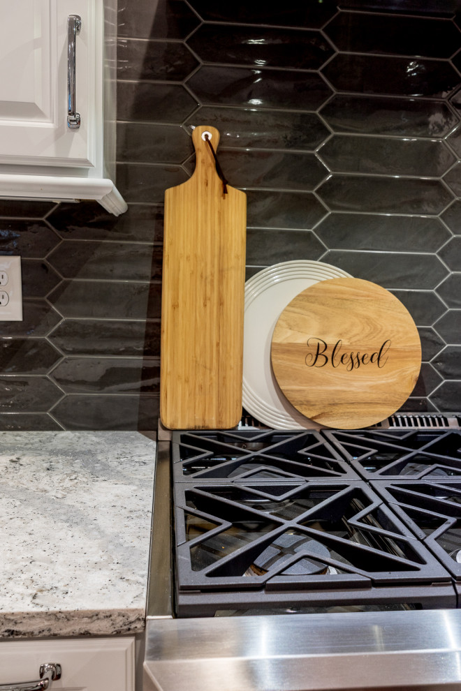 Inspiration for a large transitional single-wall brown floor eat-in kitchen remodel in Atlanta with a farmhouse sink, raised-panel cabinets, white cabinets, quartz countertops, gray backsplash, ceramic backsplash, stainless steel appliances, an island and multicolored countertops
