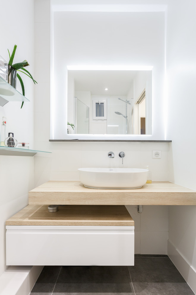 Inspiration for a small modern master bathroom in Paris with flat-panel cabinets, white cabinets, white walls, a vessel sink, wood benchtops, grey floor, beige benchtops, an alcove shower, a two-piece toilet, white tile, ceramic tile, ceramic floors and a hinged shower door.