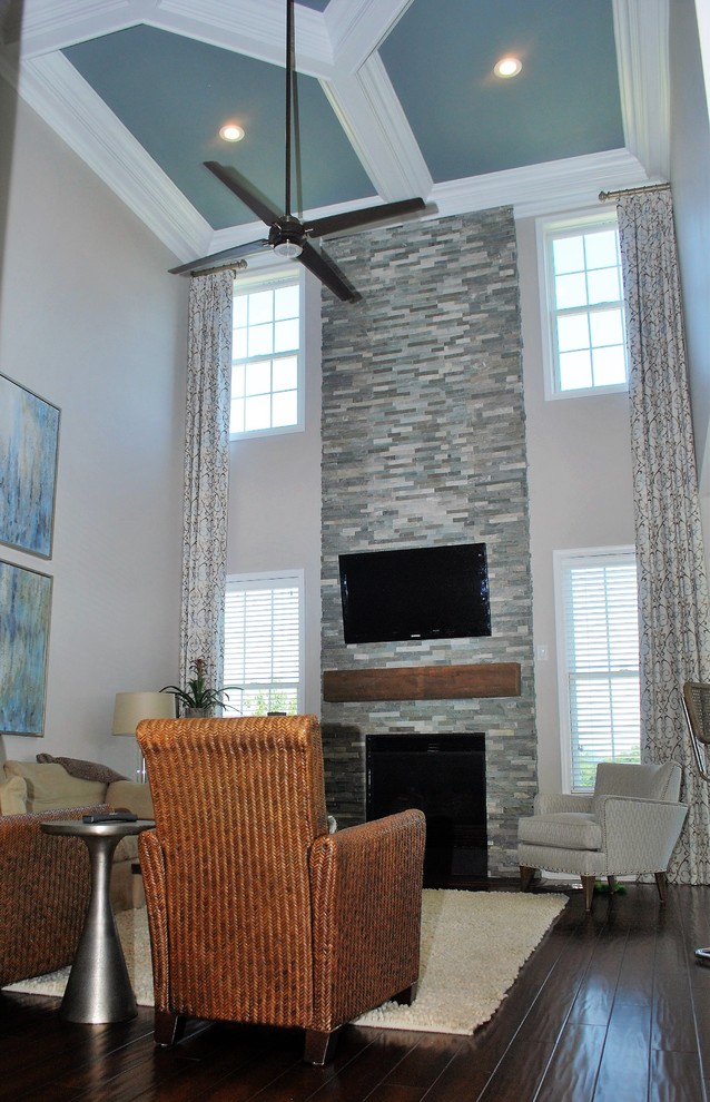 Inspiration for a transitional open concept dark wood floor and brown floor family room remodel in Philadelphia with gray walls, a standard fireplace, a stone fireplace and a wall-mounted tv