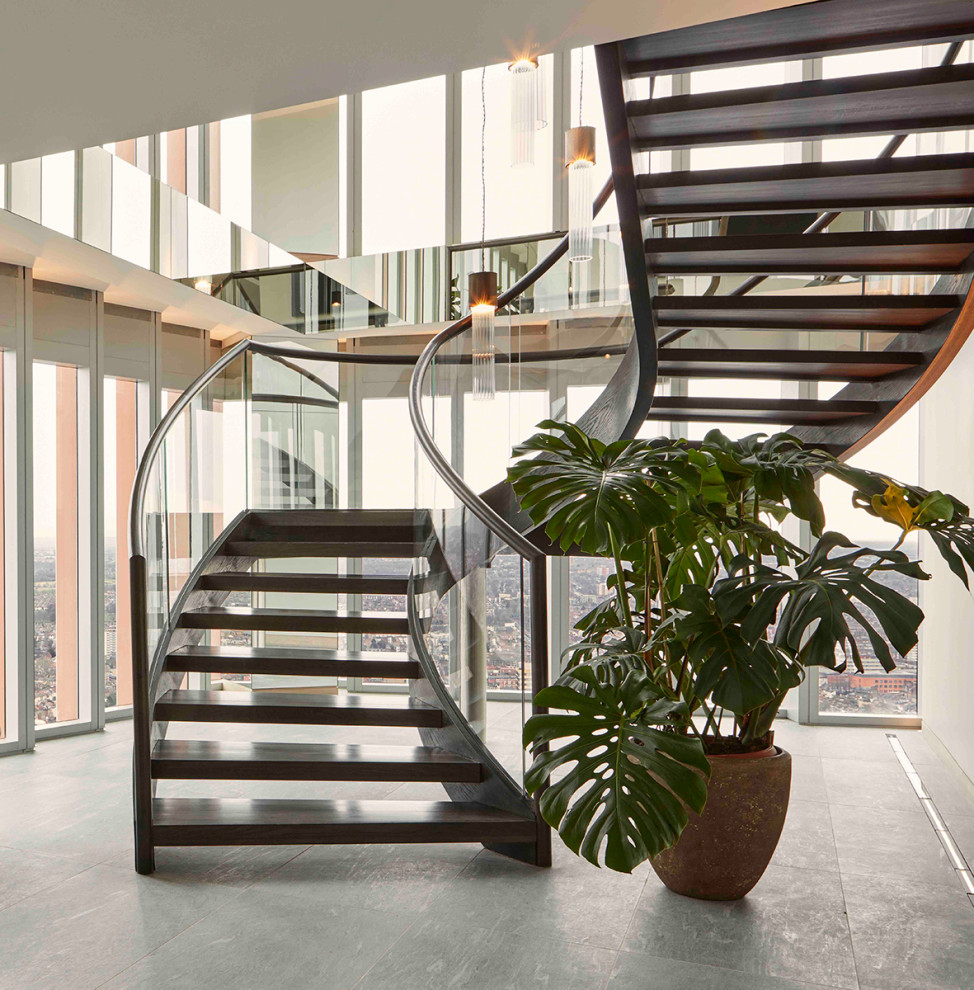 ロンドンにあるラグジュアリーな巨大なコンテンポラリースタイルのおしゃれな階段 (混合材の手すり) の写真