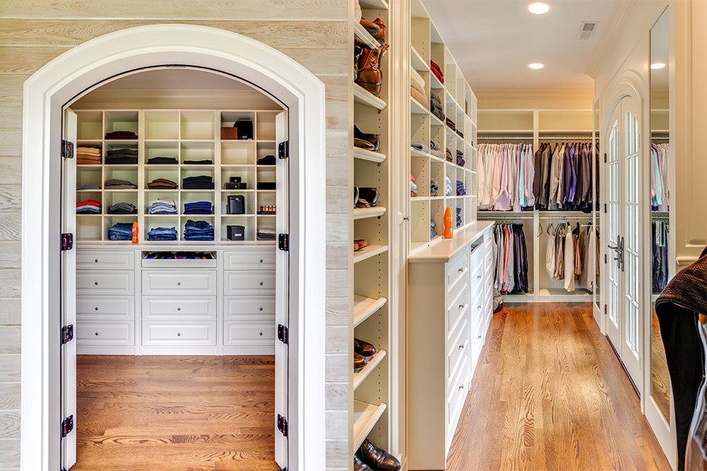 This is an example of a large traditional gender-neutral walk-in wardrobe in Other with open cabinets, white cabinets, medium hardwood floors and brown floor.