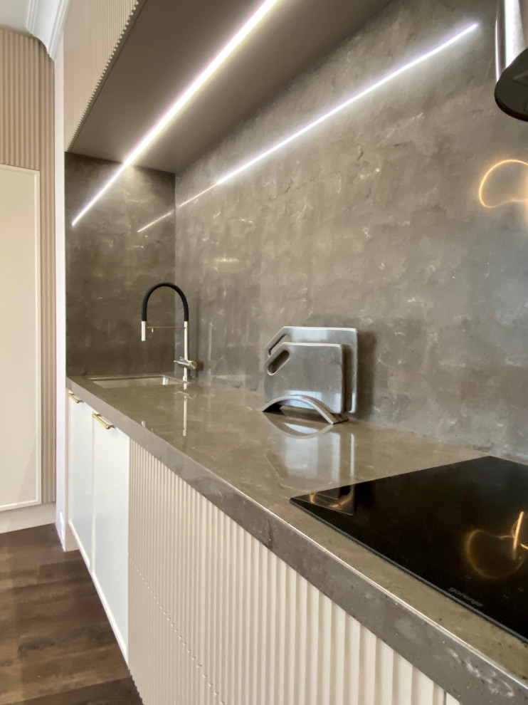 Large modern grey and white l-shaped kitchen/diner in Moscow with a submerged sink, all styles of cabinet, beige cabinets, composite countertops, brown splashback, all types of splashback, black appliances, dark hardwood flooring, no island, brown floors, brown worktops and all types of ceiling.