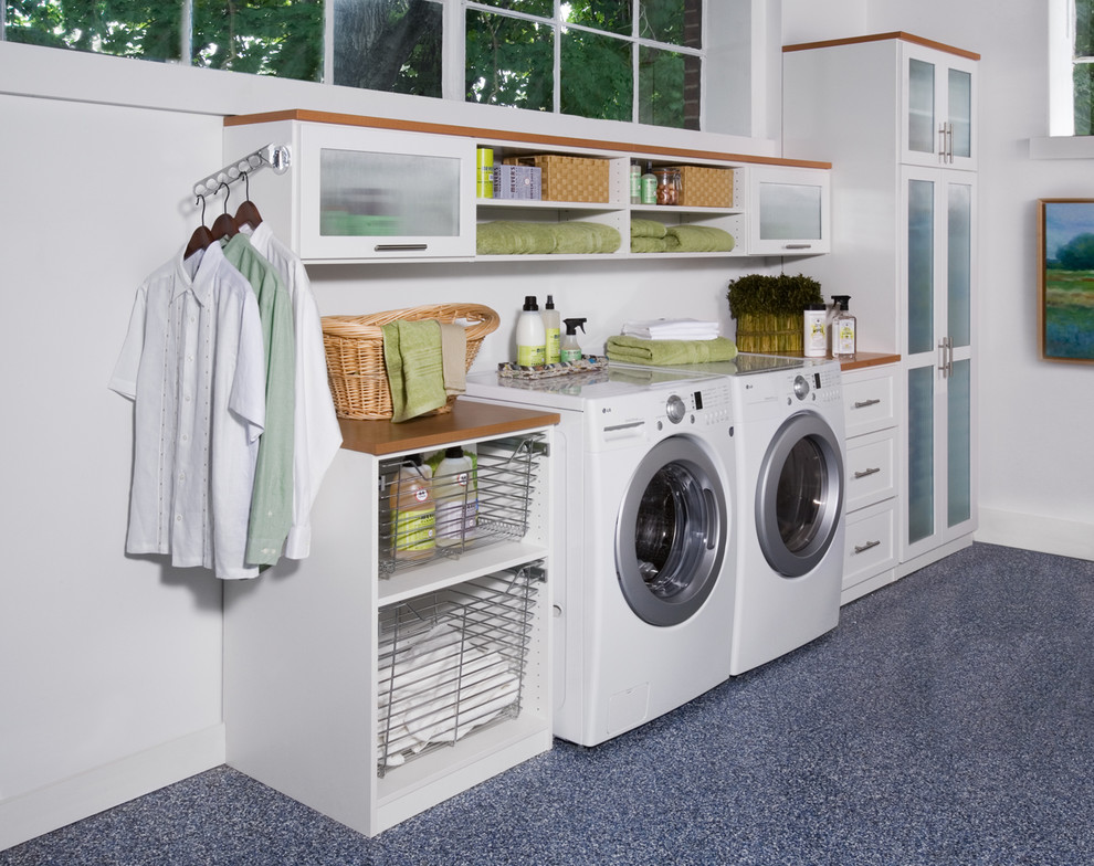 Design ideas for a mid-sized contemporary single-wall utility room in New York with linoleum floors, shaker cabinets, white cabinets, wood benchtops, white walls, a side-by-side washer and dryer and brown benchtop.