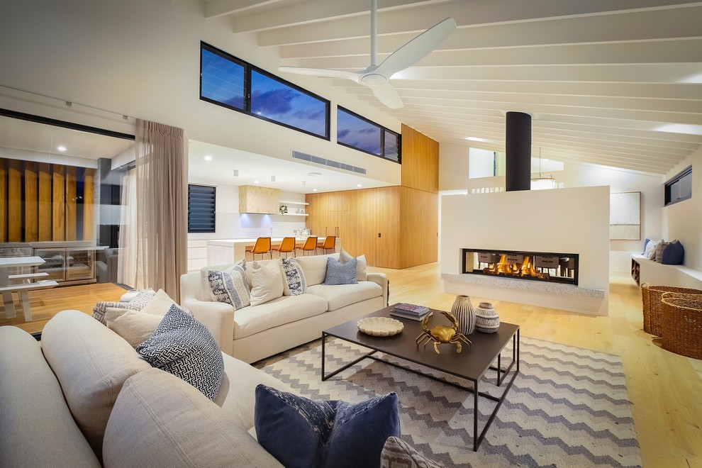 Design ideas for a contemporary formal open concept living room in Wollongong with white walls, light hardwood floors, a two-sided fireplace, no tv and brown floor.