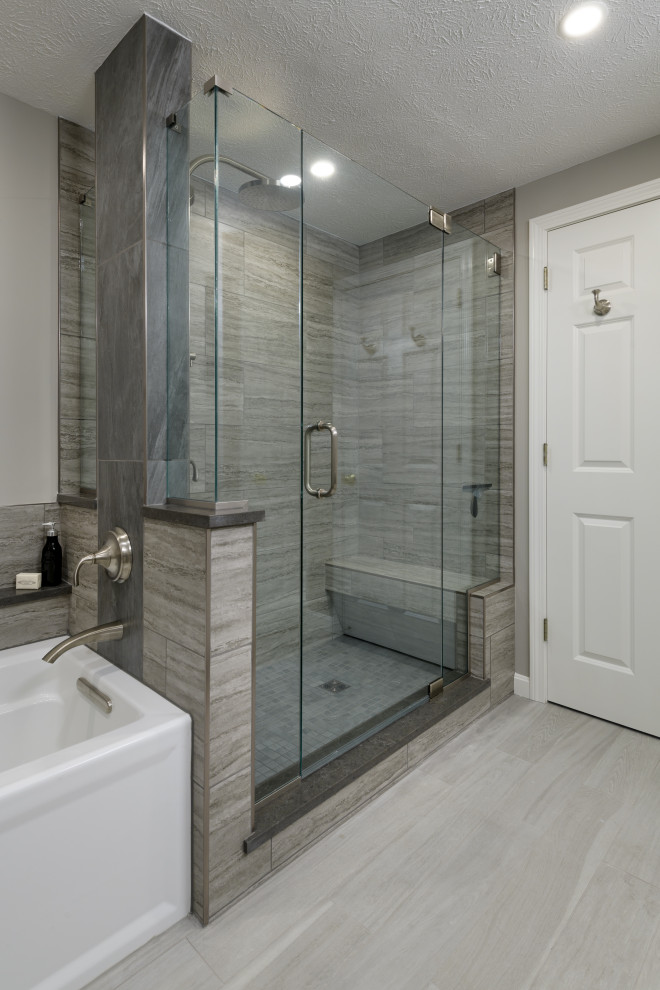 Design ideas for a large modern master bathroom in Boston with shaker cabinets, white cabinets, a drop-in tub, a double shower, a one-piece toilet, brown tile, porcelain tile, beige walls, porcelain floors, a vessel sink, granite benchtops, beige floor, a hinged shower door, black benchtops, a shower seat, a double vanity and a built-in vanity.