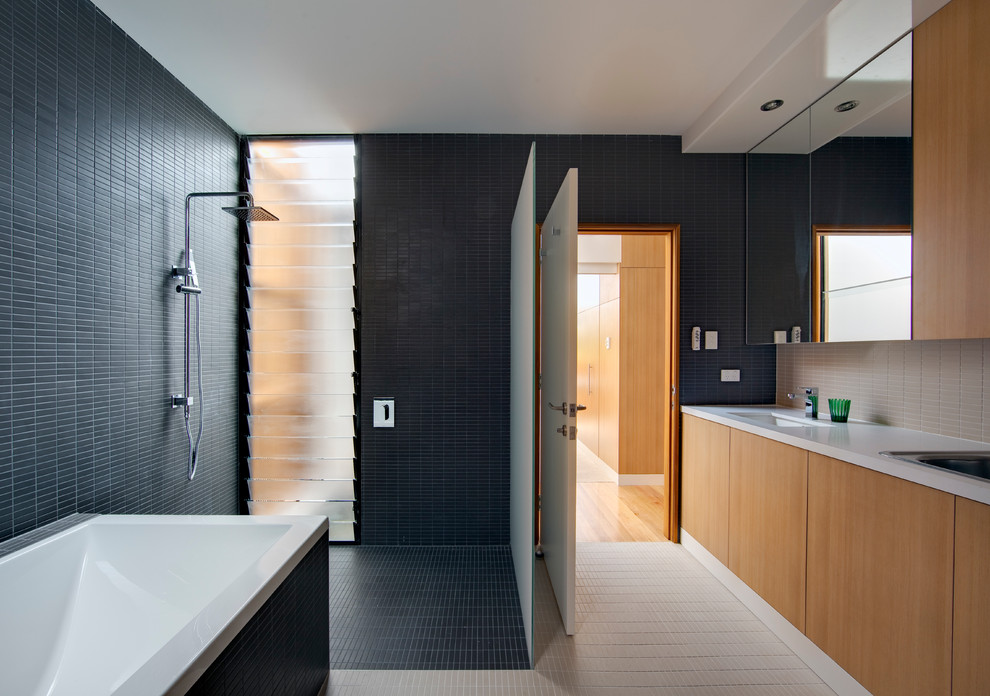 Inspiration for a contemporary bathroom in Sydney with glass-front cabinets, light wood cabinets and an open shower.