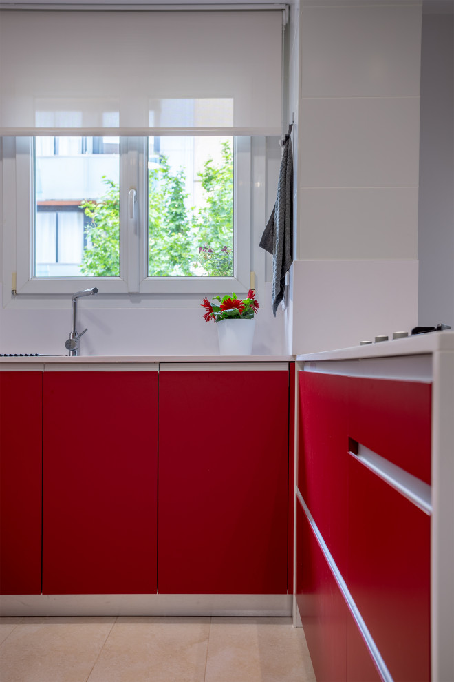 Photo of a mid-sized contemporary u-shaped open plan kitchen in Barcelona with a double-bowl sink, flat-panel cabinets, red cabinets, white splashback, stainless steel appliances, ceramic floors, a peninsula, beige floor and white benchtop.