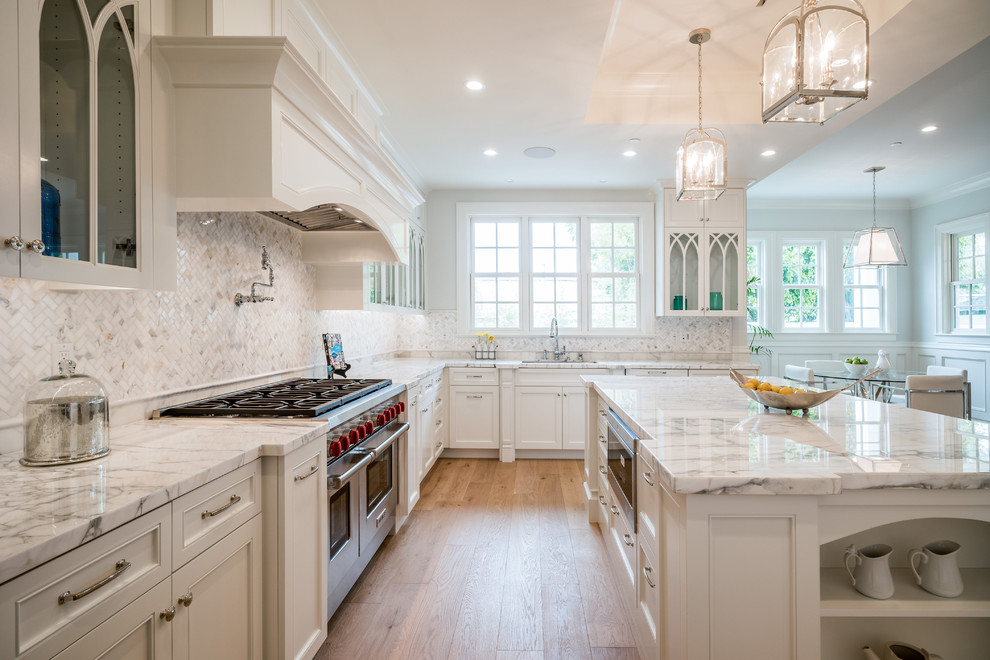 Kitchen - large traditional l-shaped light wood floor kitchen idea in Los Angeles with marble countertops, ceramic backsplash, stainless steel appliances, an island, recessed-panel cabinets, white cabinets and white backsplash