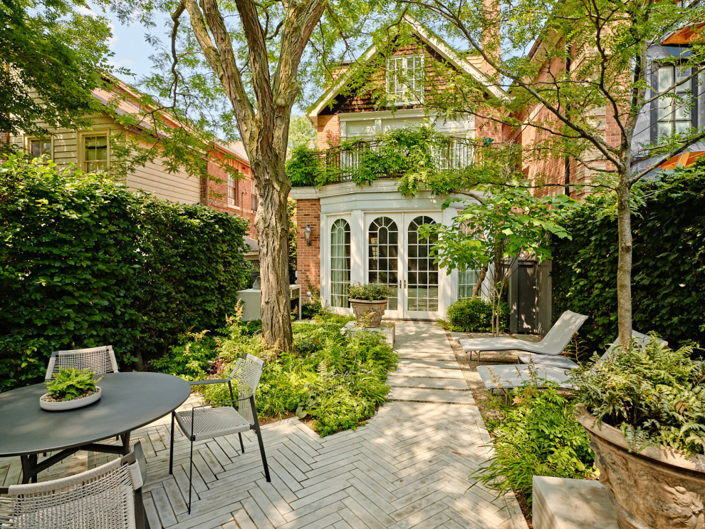 Small traditional backyard patio in Toronto with natural stone pavers.