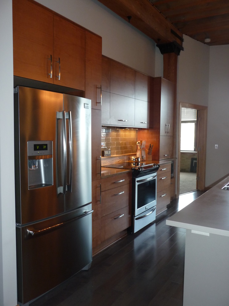 Mid-sized minimalist galley medium tone wood floor eat-in kitchen photo in Milwaukee with an undermount sink, flat-panel cabinets, medium tone wood cabinets, quartz countertops, beige backsplash, glass tile backsplash, stainless steel appliances and an island