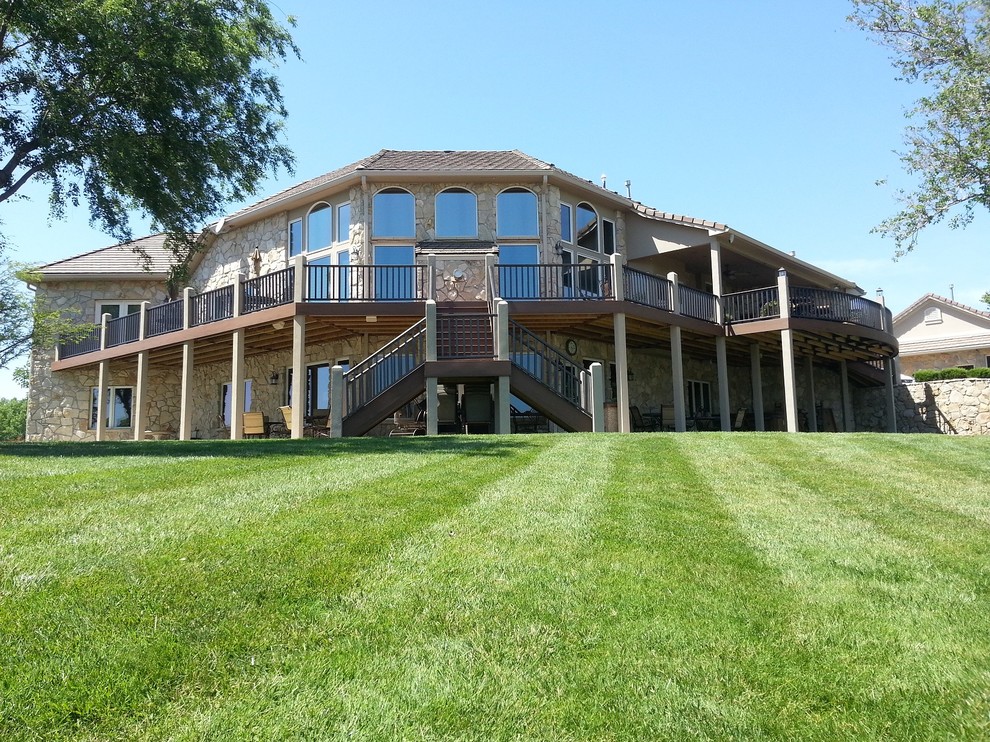 Inspiration for an expansive traditional backyard deck in Wichita with a roof extension.