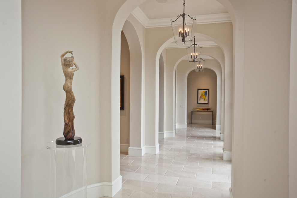 This is an example of a large transitional hallway in Other with beige walls, travertine floors and beige floor.