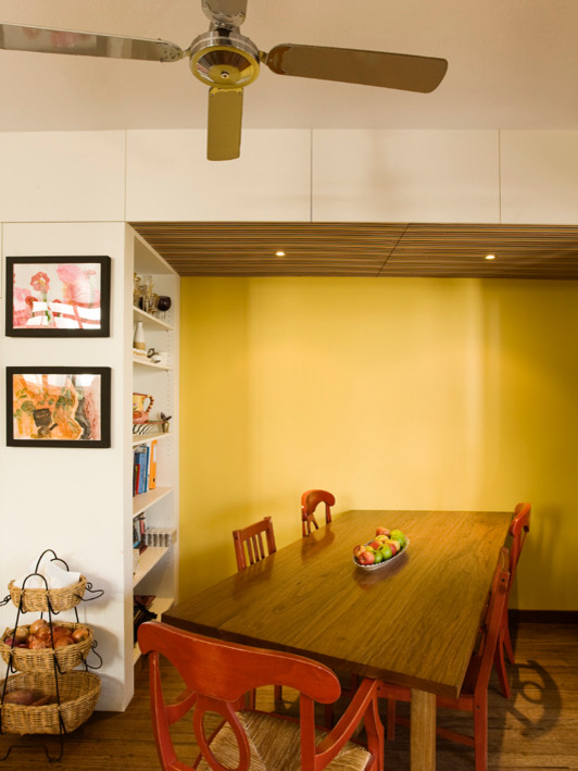 На фото: кухня-столовая среднего размера в современном стиле с желтыми стенами, паркетным полом среднего тона, коричневым полом и потолком с обоями без камина