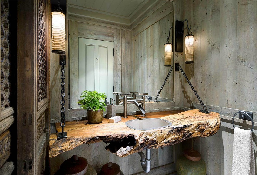 This is an example of a country powder room in Oklahoma City with a drop-in sink, wood benchtops and brown walls.