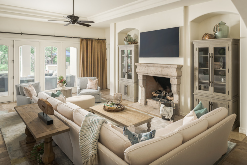 Large mediterranean open concept family room in Phoenix with a standard fireplace, a stone fireplace surround, a wall-mounted tv, brown floor, terra-cotta floors and coffered.