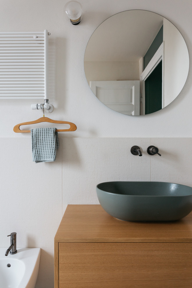 Photo of a scandinavian bathroom in Milan with brown cabinets, a wall-mount toilet, beige tile, porcelain tile, white walls, a vessel sink, wood benchtops, beige floor, brown benchtops, a single vanity, a floating vanity and flat-panel cabinets.