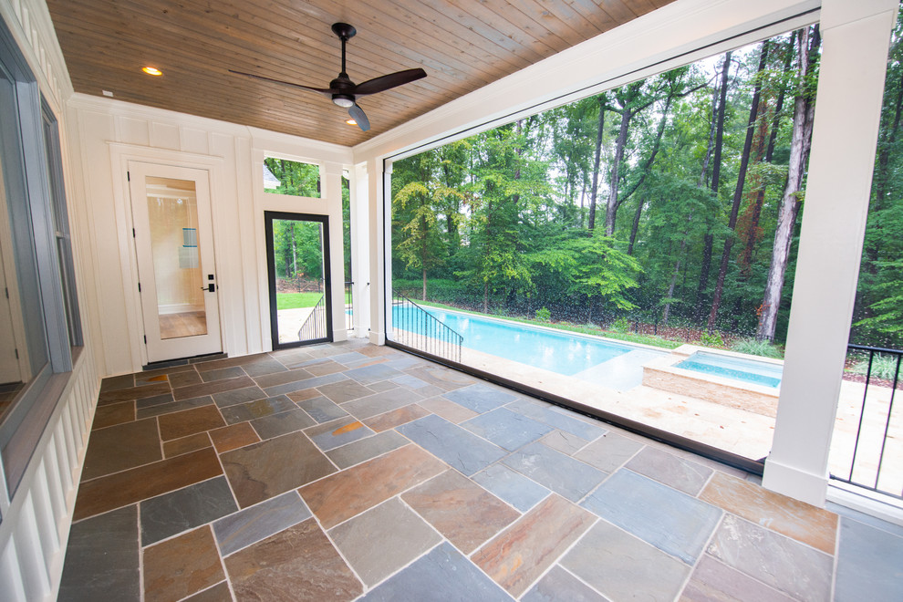 Country backyard screened-in verandah in Raleigh with natural stone pavers and a roof extension.