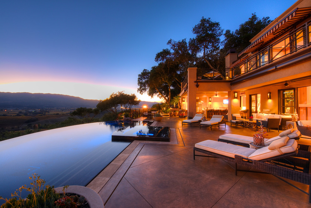 Photo of an expansive country courtyard custom-shaped infinity pool in San Francisco with a water feature and stamped concrete.