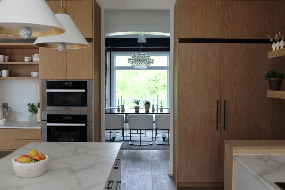 Inspiration for a large contemporary kitchen in Denver with a submerged sink, flat-panel cabinets, light wood cabinets, marble worktops, white splashback, metro tiled splashback, light hardwood flooring and white worktops.