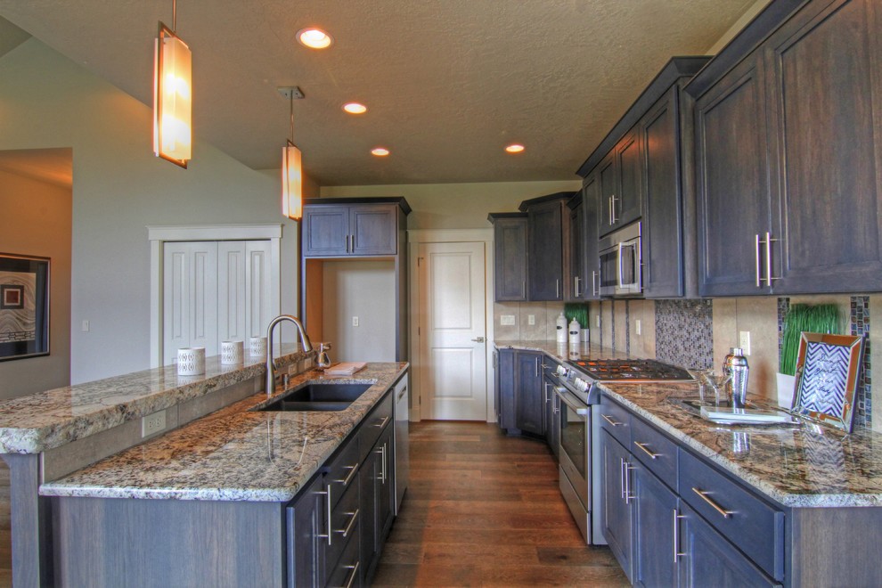 Open concept kitchen - mid-sized transitional galley dark wood floor and brown floor open concept kitchen idea in Seattle with a double-bowl sink, recessed-panel cabinets, dark wood cabinets, granite countertops, stainless steel appliances and an island
