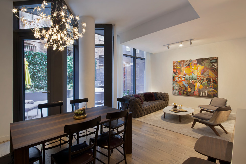 Photo of a mid-sized contemporary enclosed family room in New York with white walls and light hardwood floors.