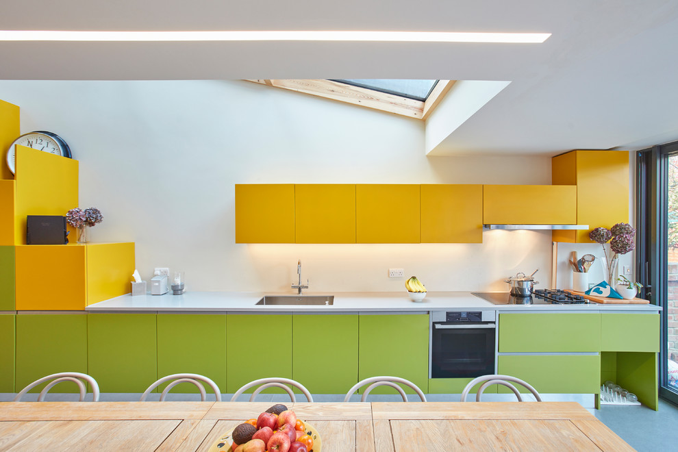 This is an example of a mid-sized contemporary single-wall eat-in kitchen in London with an undermount sink, flat-panel cabinets, no island, grey floor and green cabinets.