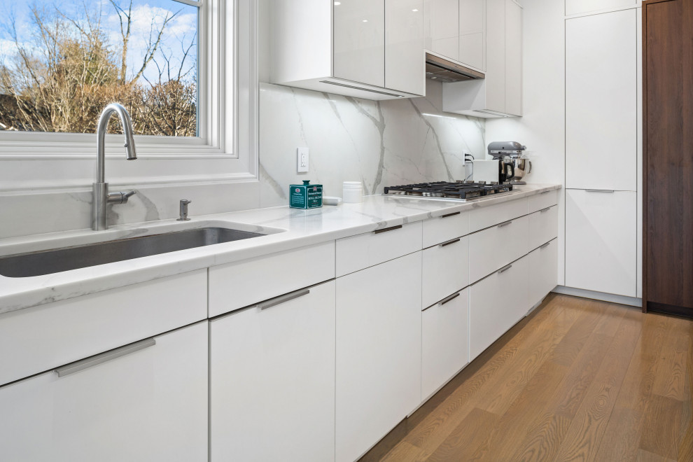 Photo of a large modern eat-in kitchen in New York with flat-panel cabinets, dark wood cabinets, quartzite benchtops, with island and white benchtop.