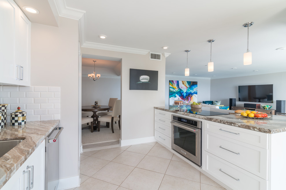 Eat-in kitchen - mid-sized transitional galley porcelain tile eat-in kitchen idea in Miami with an undermount sink, shaker cabinets, white cabinets, granite countertops, white backsplash, subway tile backsplash, stainless steel appliances and a peninsula
