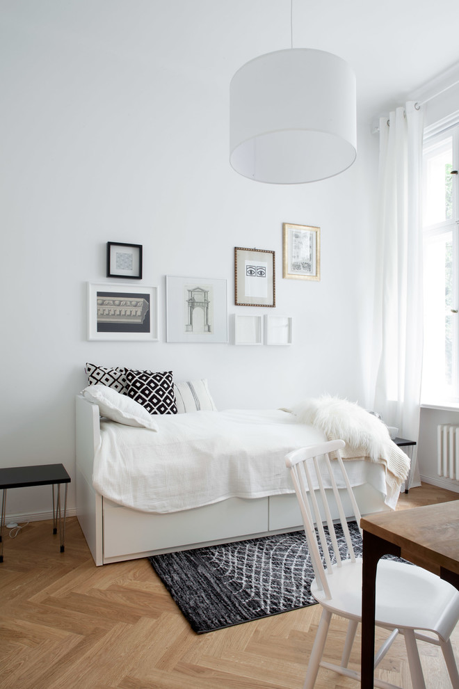 Design ideas for a small scandinavian bedroom in Berlin with white walls, no fireplace, light hardwood floors and beige floor.