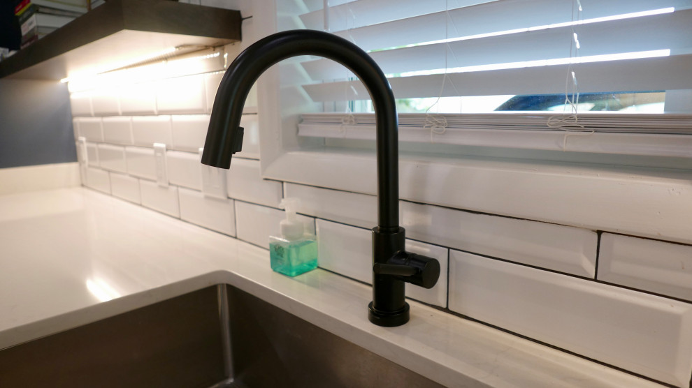 Inspiration for a mid-sized transitional galley porcelain tile and gray floor eat-in kitchen remodel with an undermount sink, shaker cabinets, white cabinets, quartz countertops, white backsplash, subway tile backsplash, black appliances, no island and white countertops