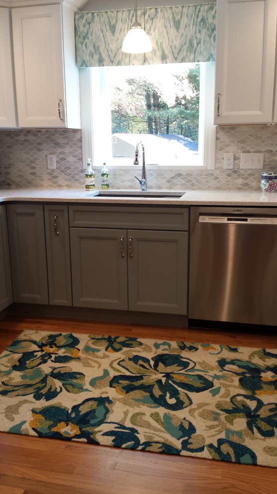Example of a mid-sized transitional u-shaped light wood floor kitchen design in Boston with an undermount sink, quartz countertops, stainless steel appliances and a peninsula