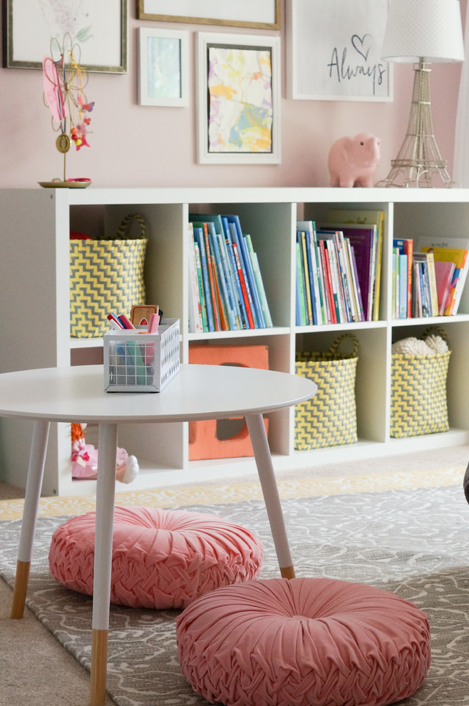 This is an example of a mid-sized transitional kids' bedroom for kids 4-10 years old and girls in Other with pink walls, carpet and beige floor.