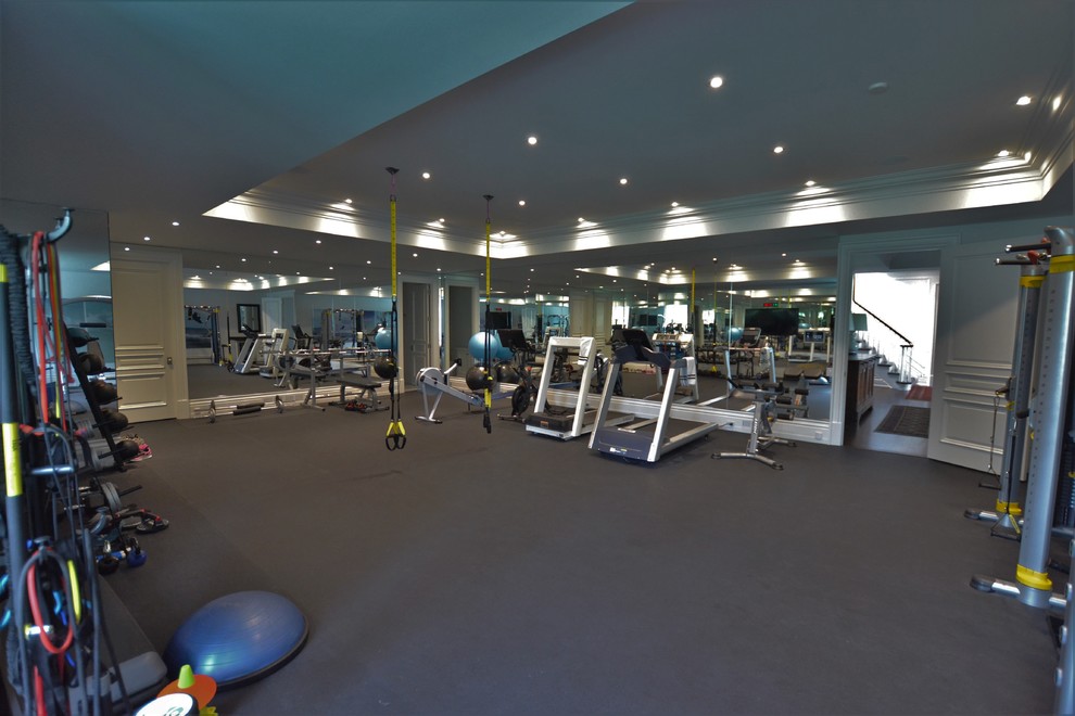 This is an example of a traditional home weight room in Toronto with black floor.