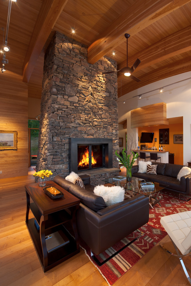Design ideas for a contemporary formal open concept living room in Other with no tv, white walls, medium hardwood floors, a two-sided fireplace and a stone fireplace surround.